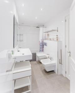 a white bathroom with two sinks and a mirror at CASA PRINCESA in Alcudia