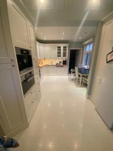a kitchen with white appliances and a dining room at Executive 5 Bedrooms House in Lillestrøm Central - 5 mins walk from Lillestrøm Station in Lillestrøm