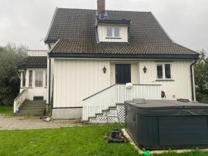una casa blanca con techo negro y patio en Executive 5 Bedrooms House in Lillestrøm Central - 5 mins walk from Lillestrøm Station en Lillestrøm