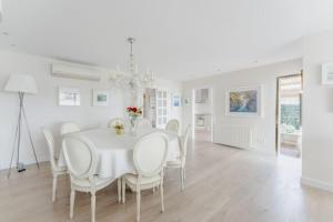 a white dining room with a white table and chairs at CASA PRINCESA in Alcudia