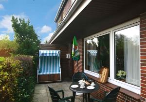 韋斯特蘭的住宿－Apartments in Westerland/Sylt 38535，一个带桌椅的庭院和一个窗户。