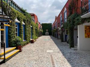 un callejón de piedra con edificios y plantas en Mesón Yollotl, en Puebla