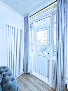 a living room with a door and a window at Modern Finsbury Park Apartment in London