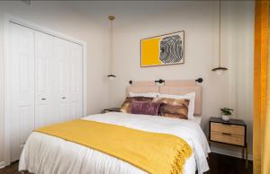 um quarto com uma cama grande e um cobertor amarelo em NEW! Spacious Art Deco Modern 5 BD/3BA Condo em Chicago