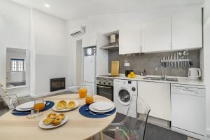 a kitchen with a table with plates of food on it at WHome Urban Escape: 1-BR w/mezzanine near Campo Ourique in Lisbon