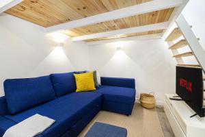 a blue couch in a living room with wooden ceilings at WHome Urban Escape: 1-BR w/mezzanine near Campo Ourique in Lisbon