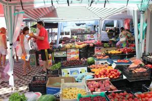 a group of people in a market with fruits and vegetables at Hotel Electra in Pomorie