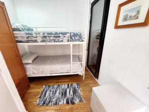 een kleine kamer met een stapelbed en een tapijt bij Hostel Pepe Viajes in Madrid