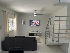 salon z kanapą i telewizorem na ścianie w obiekcie Mandeville Vacation Home w mieście Mandeville