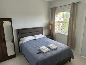 a bedroom with a bed with two towels on it at Mandeville Vacation Home in Mandeville