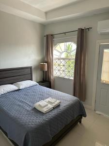 a bedroom with a bed with two towels on it at Mandeville Vacation Home in Mandeville