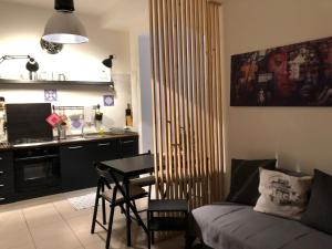 a kitchen and a living room with a table and a couch at Marina Design Apartment in Marina di Ragusa