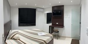 a small bedroom with a bed and a window at Hotel Lá Torre in São Paulo