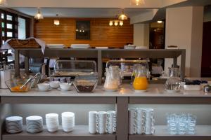 uma cozinha com um balcão com pratos e sumo de laranja em Hotel Germania em Puerto Varas