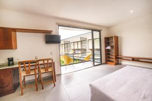 um quarto com uma cama e uma cozinha com uma grande janela em Deluxe Apartmets Azure em Bacalar