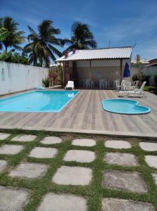a backyard with a swimming pool and a house at DUPLEX 5 ESTRELAS A 100 METROS DA PRAIA in Porto Seguro