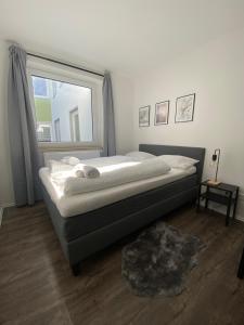 een slaapkamer met een groot bed en een raam bij Im Zentrum, Modernes City Apartment in Würzburg