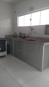 a kitchen with a counter with a sink and a stove at DUPLEX 5 ESTRELAS A 100 METROS DA PRAIA in Porto Seguro