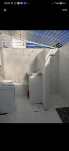 a white bathroom with a toilet and a sink at DUPLEX 5 ESTRELAS A 100 METROS DA PRAIA in Porto Seguro