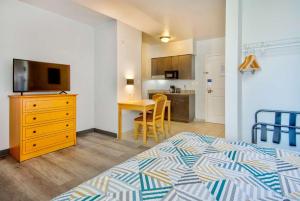ein Schlafzimmer mit einem Bett und einem TV sowie eine Küche in der Unterkunft Studio 6-Bakersfield, CA in Bakersfield