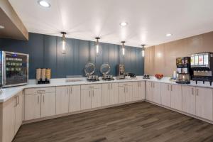 a kitchen with white cabinets and a blue wall at Best Western Bellemont Shadow Mountain Inn in Flagstaff