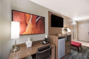 um quarto de hotel com uma secretária e uma televisão de ecrã plano em Best Western Bellemont Shadow Mountain Inn em Flagstaff