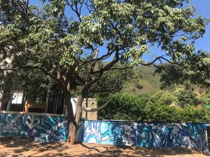 uma árvore em frente a uma parede com graffiti em Villa Coco em Taganga