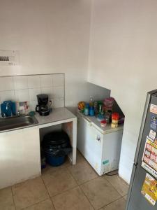 una pequeña cocina con encimeras blancas y fregadero en Hostal MONARCA en Jamundí