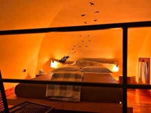 Una cama en una habitación con pájaros volando sobre ella en L'antico Pozzo, en Sulmona