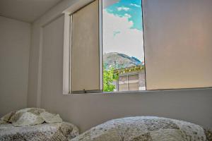 a bedroom with a bed and a window with a view at Mountain Home in Huaraz