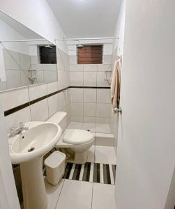 a white bathroom with a sink and a toilet at Mountain Home in Huaraz