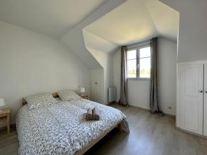 a white bedroom with a bed and a window at Le cosy cottage d'Alex in Ardon