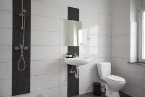 a white bathroom with a toilet and a sink at T&K Apartments - Apartments 20 Min to MESSE DUS in Krefeld