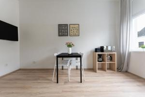 una mesa con un jarrón de flores en una habitación en T&K Apartments - Apartments 20 Min to MESSE DUS, en Krefeld