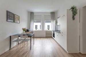 eine Küche und ein Esszimmer mit Tisch und Stühlen in der Unterkunft T&K Apartments - Apartments 20 Min to MESSE DUS in Krefeld + 17 Fotos