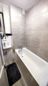La salle de bains est pourvue d'une baignoire et d'un lavabo. dans l'établissement Spacious flat with 2 to 3 bedrooms in Central London, à Londres