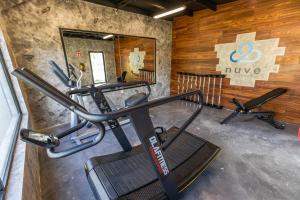a gym with a treadmill and two exercise bikes at Hotel Nuve Gomez Palacio in G&oacute;mez Palacio