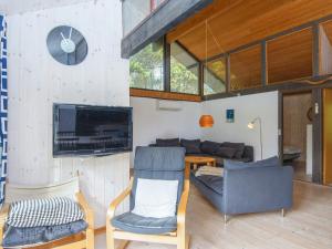 a living room with a couch and a tv and chairs at Holiday home Nørre Nebel XIV in Nørre Nebel