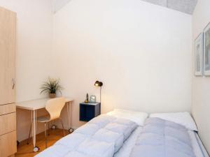 a white bedroom with a bed and a desk at Holiday home Ansager XXXVI in Ansager