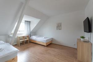 Habitación blanca pequeña con cama y TV en T&K Apartments - Apartments 20 Min to MESSE DUS, en Krefeld