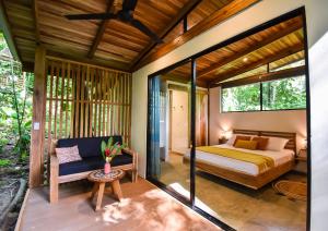 ein Schlafzimmer in einem Haus mit einem Bett und einem Sofa in der Unterkunft Satta Lodge in Puerto Viejo