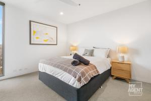 um quarto com uma cama grande e uma mesa de cabeceira em Experience Port Melbourne on Delightful Dow Street em Melbourne