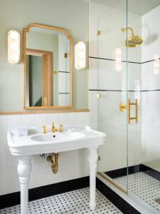 a bathroom with a sink and a glass shower at Palihouse Hyde Park Village in Tampa