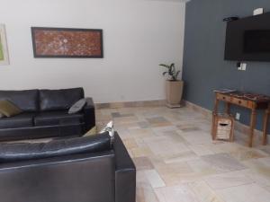 uma sala de estar com um sofá e uma mesa em Riviera Green Residence 232 em Bertioga