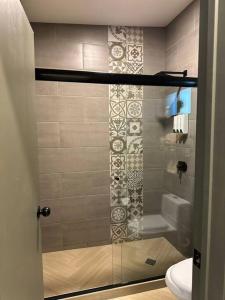 uma casa de banho com uma cabina de duche em vidro e um WC. em Habitación 21 - Green Casitas em Ensenada
