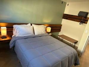 uma grande cama azul num quarto com duas lâmpadas em Habitación 21 - Green Casitas em Ensenada