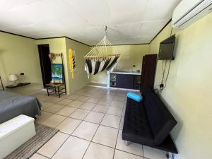 una sala de estar con cama y TV y una habitación en Hotel Azul Coral, en Cahuita