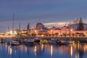 un gruppo di barche ormeggiate in un porto di notte di Apartamento Figueira da Foz - Praia do Relógio a Figueira da Foz