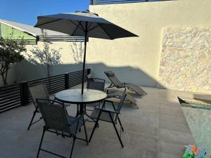 stół i krzesła z parasolem na patio w obiekcie Habitación 22 - Green Casitas w mieście Ensenada