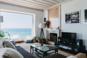 sala de estar con sofá, TV y mesa en Villa Tamar - Azenhas do Mar en Azenhas do Mar